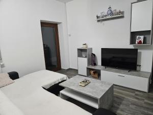 a living room with a couch and a tv and a table at Eight Home in Horia