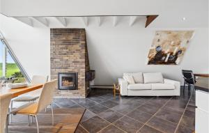 a living room with a fireplace and a couch at Holiday Home Marievænget in Tørresø