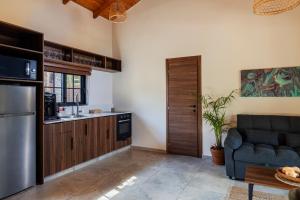 a living room with a couch and a kitchen at Tal Shahar Rooms in Tal Shaẖar