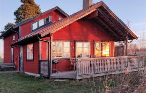 a red house with a porch and a deck at Amazing Home In Strängnäs With Sauna in Aspö