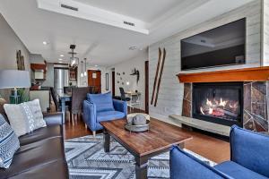een woonkamer met een bank en een open haard bij Classic Hideaway Elegant 2BD 2BTH in Canmore