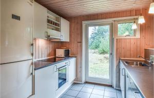 a kitchen with a refrigerator and a sink at Holiday Home Per Knoldsvej Blåvand Ii in Blåvand