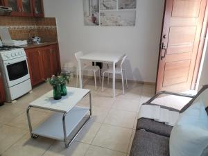 a living room with a table and a kitchen at small apartment in Santo Domingo