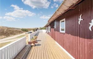 ein Holzsteg, der zu einem roten Gebäude führt in der Unterkunft Holiday Home Hvide Sande 32 in Havrvig