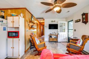a living room with a ceiling fan and a kitchen at Kill Devil Hills Vacation Rental, Walk to Beach! in Kill Devil Hills