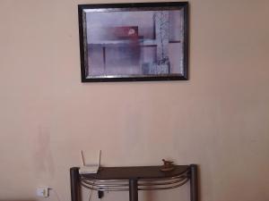a picture hanging on a wall with a table at Pequeña casa vacacional en Ensenada Mx in Ensenada