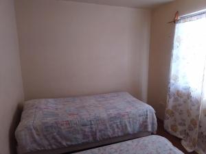 a small bedroom with a bed and a window at Pequeña casa vacacional en Ensenada Mx in Ensenada