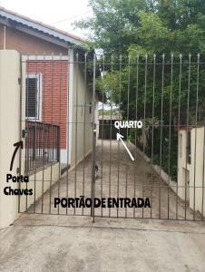 a gate with labels on it in front of a house at Suíte separada da casa principal in São Pedro +10 photos