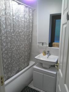 a bathroom with a shower curtain and a sink at Real Home In Northampton in Overstone +39 photos