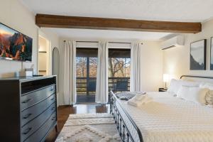 a bedroom with a bed with a dresser and a window at Sweet Dreams are Made of Skis in Sugar Mountain