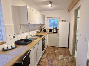 a kitchen with white cabinets and a white refrigerator at Little Wish in Gdańsk