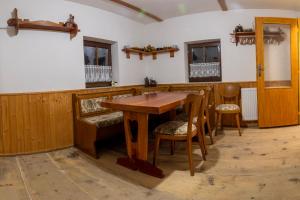 a dining room with a wooden table and chairs at Chata Petrov nad Desnou in Petrov nad Desnou