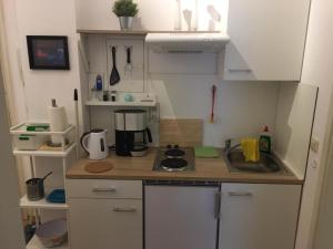 una piccola cucina con armadi bianchi e piano di lavoro di Ferienwohnung Chemnitz Kaßberg II a Chemnitz