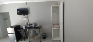 a small room with a desk and a television at Ammigos Guesthouse in Klerksdorp