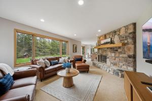 un soggiorno con divani e camino in pietra di Cherry Hill - Minutes to Downtown! Hot Tub, Spacious Yard & Dogs OK! a Sister Bay