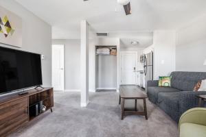 a living room with a couch and a tv at Spacious 2BR Apt on Mass Ave w Kitchen in Indianapolis