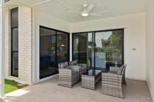 a patio with chairs and a ceiling fan at Brand New Modern 4BR House with Parking Yard Mall and Park in Capalaba