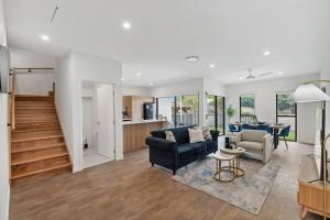 a living room with a couch and a table at Brand New Modern 4BR House with Parking Yard Mall and Park in Capalaba
