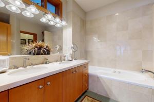 ein Badezimmer mit zwei Waschbecken und einer Badewanne und einem Spiegel in der Unterkunft Ontario Haven in Park City + 24 Fotos