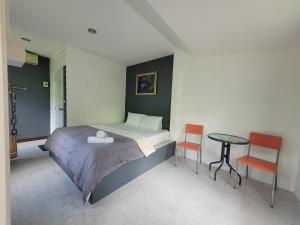 a bedroom with a bed and a table and chairs at Sawan Srang Nang Kaew in Takhop