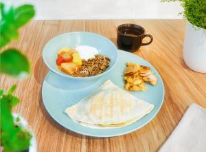 a blue plate with two bowls of food and a tortilla at Altio Hotel in Cali
