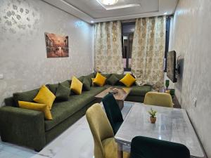 a living room with a green couch and yellow pillows at Appart moderne nador al jadid près de la corniche in Nador
