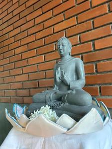 a statue of a buddha sitting in a bowl at Monkey Banana Villa in Galle