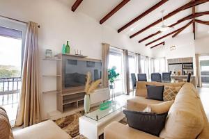 a living room with a couch and a tv at Spacious Bright & Airy Penthouse C at Playa Venao in Playa Venao