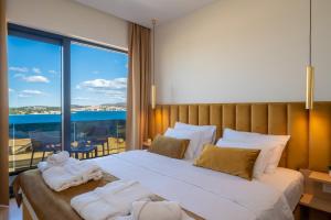 a bedroom with a large bed with towels on it at Villa Ramarin III with infinity heated pool, jacuzzi and sauna by the sea in Rogoznica in Rogoznica +50 photos