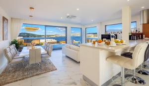 a kitchen and living room with a view of the ocean at Villa Ramarin III with infinity heated pool, jacuzzi and sauna by the sea in Rogoznica in Rogoznica