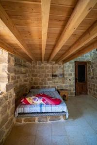 Tunisにあるsuite-2 rooms-4 beds-2 bathroomsの木製天井の石造りの部屋のベッド1台