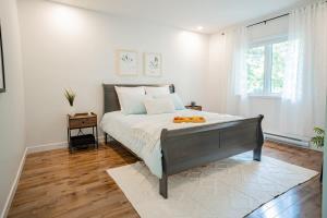a bedroom with a large bed and a window at La Pause - Peaceful by the river in Chertsey
