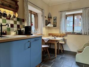 a kitchen with a sink and a table at Lohei - Historisches Zuhäusl in Unterwössen