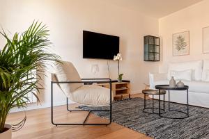 a living room with a chair and a tv at Gabrielles Roof New Modern Apartment in Livorno