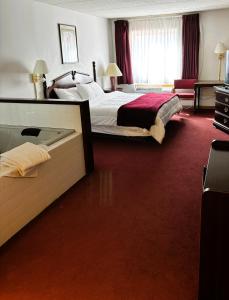 a hotel room with two beds with red carpet at Voyageur Inn and Conference Center in Reedsburg +32 photos