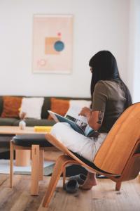 a woman sitting on a chair with a laptop at Chalet Komorebi with spa - Meli 1 in Sainte Béatrix