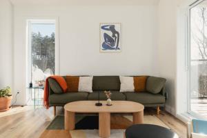 a living room with a couch and a coffee table at Chalet Komorebi with spa - Meli 1 in Sainte Béatrix