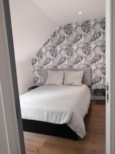 a bedroom with a bed with a large headboard at En pleine verdure in Glaignes
