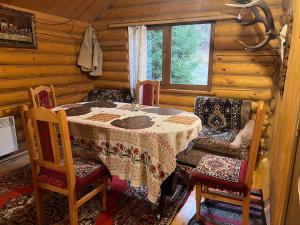 a dining room with a table and chairs in a cabin at Farmstead Lisova in Mizhhirya