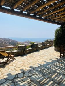 a patio with a roof with a table and chairs at Anastasia Luxury Villas in Gavrio