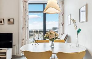 a dining room with a table and chairs and a window at Fanø Bad, Lejl 74 in Fanø