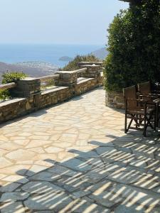a patio with chairs and tables on a hill at Anastasia Luxury Villas in Gavrio