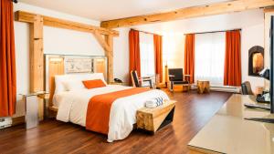 een slaapkamer met een groot bed en een bureau bij Le Baluchon Éco-villégiature in Saint-Paulin +90 foto's