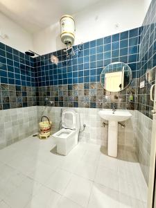 a bathroom with a sink and a toilet and a mirror at BASERAA BIR - A Slow Traveler's Home in Bīr