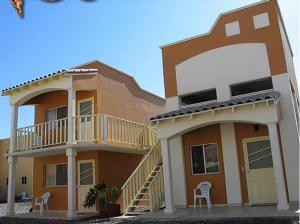 duży dom z balkonem i 2 krzesłami w obiekcie Hotel Los Caracoles w mieście Guerrero Negro