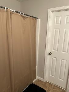a bathroom with a shower and a white door at Bea's place-1 in Morrow