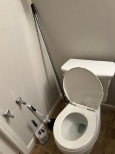 a bathroom with a white toilet with a squeegee at Bea's place-1 in Morrow