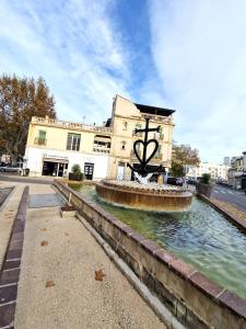 un edificio con una fuente en medio de una calle en La Verrerie, en Arles 3 fotos más