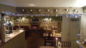 um restaurante com um bar e uma lareira em The Cavendish Arms em Cartmel