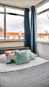 a bedroom with a bed with two pillows and a window at Parede, Sun Beach in Parede